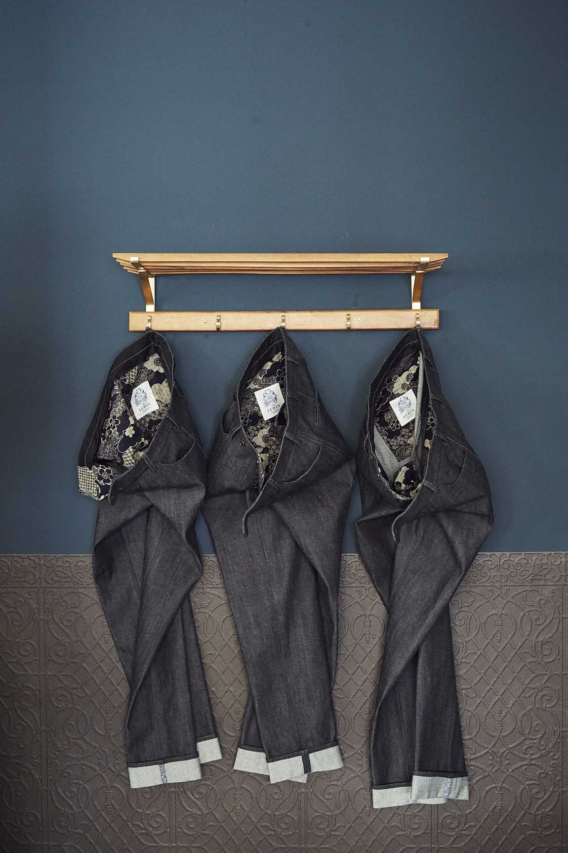 Drei Denim Hosen hängen an einer Garderobe