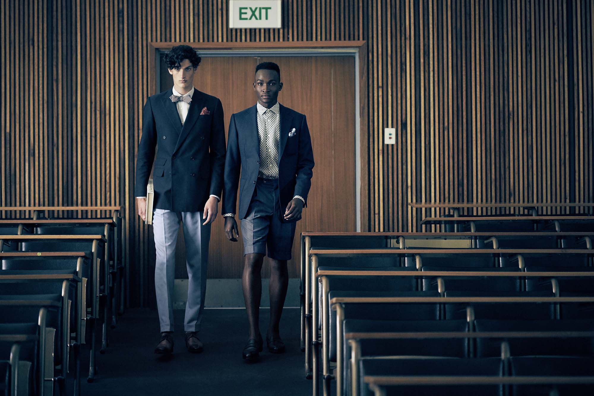 Zwei Männer laufen einen Hörsaal hinunter